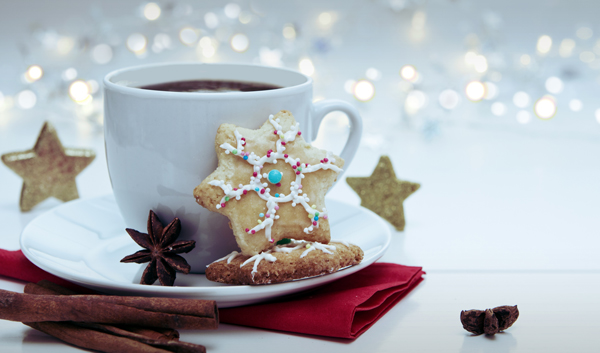 Tasse Kaffee mit Weihnachtsplätzchen und weihnachtlichen Gewürzen